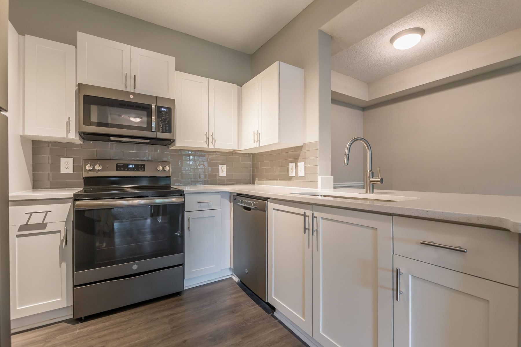 Luxury apartment kitchen with stainless steel appliances, granite countertops, and lots of storage space
